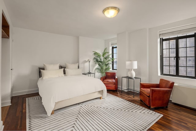 bedroom with baseboards and wood finished floors