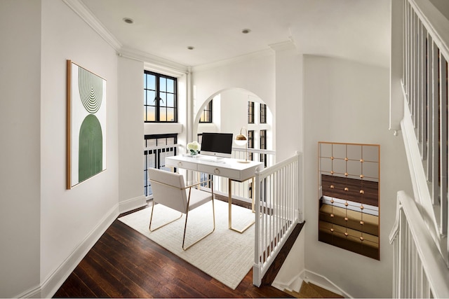 home office with baseboards, arched walkways, dark wood-type flooring, and ornamental molding