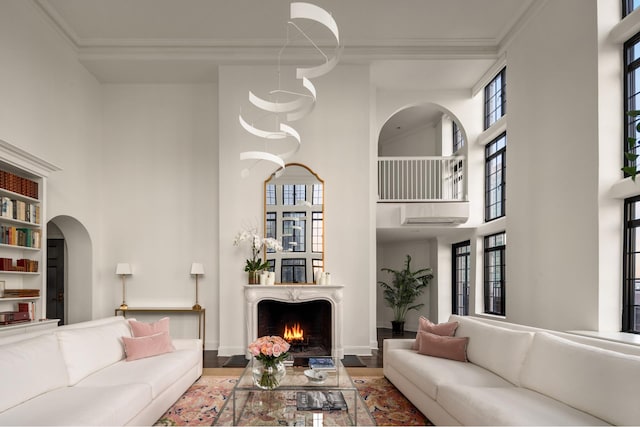 5 Tudor City Place Penthouse7, New York City, NY 10017 - living room with arched walkways, a high ceiling, crown molding, plenty of natural light, and wood finished floors