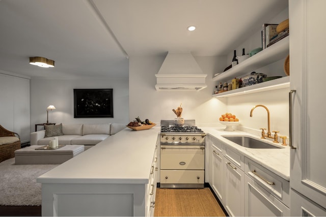 5 Tudor City Place Penthouse7, New York City, NY 10017 - kitchen featuring stainless steel stove, a sink, custom exhaust hood, open floor plan, and a peninsula