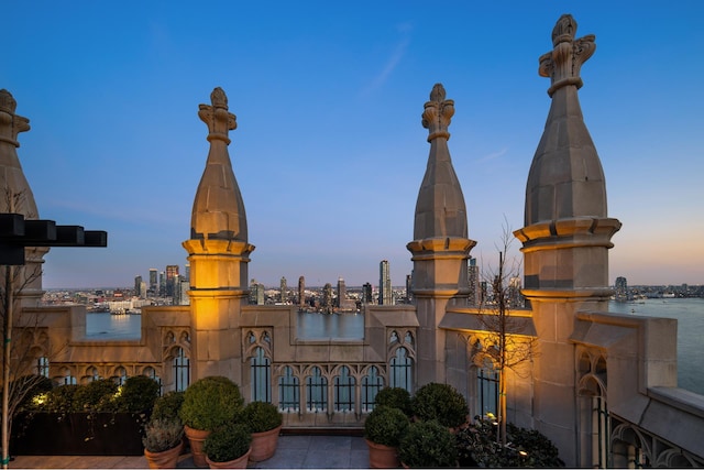 property at dusk featuring a view of city and a water view