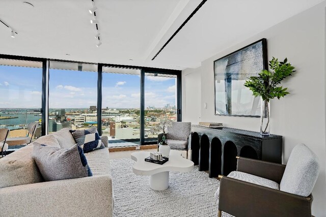 living room featuring a wall of windows and rail lighting