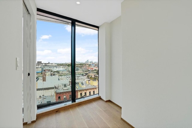 unfurnished room featuring floor to ceiling windows and light wood-type flooring