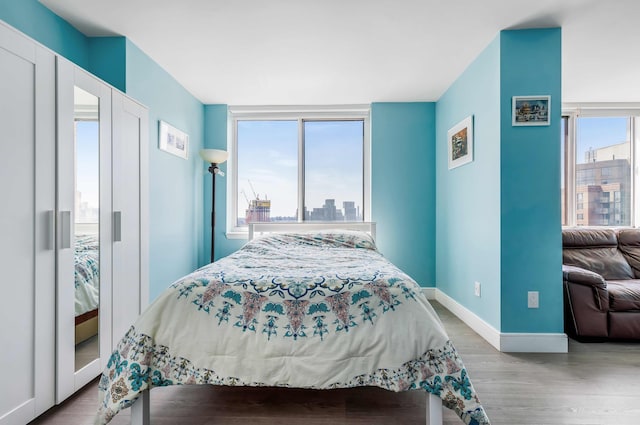 bedroom with baseboards and wood finished floors
