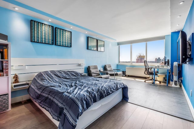 bedroom featuring baseboards, wood finished floors, and recessed lighting