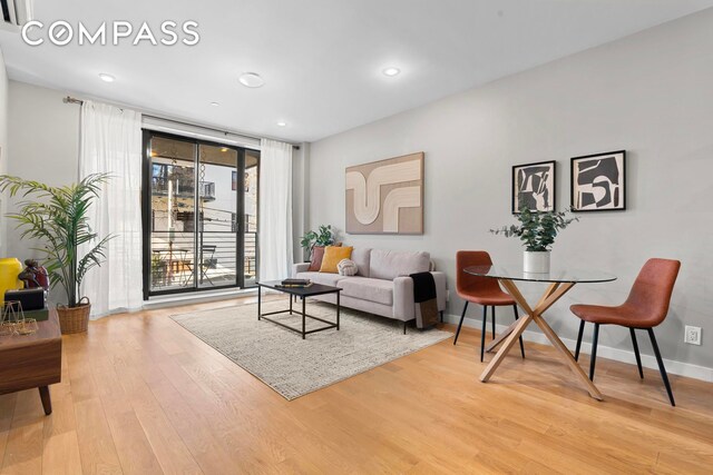 living room featuring floor to ceiling windows and light hardwood / wood-style flooring