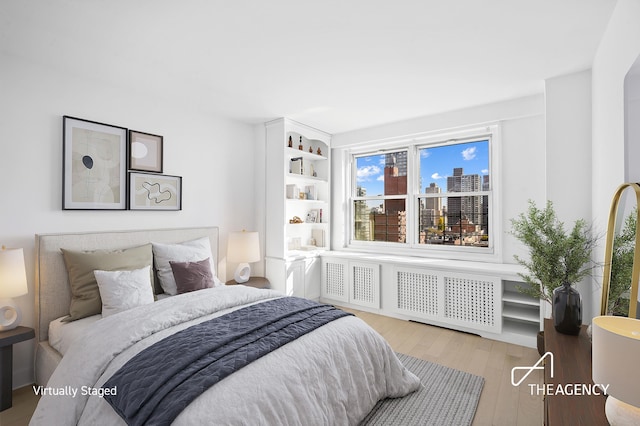 bedroom with radiator and wood finished floors