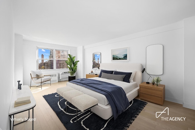 bedroom with radiator heating unit and wood finished floors