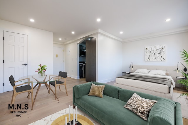 bedroom with ornamental molding and light hardwood / wood-style floors