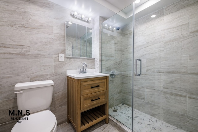 bathroom with vanity, toilet, an enclosed shower, and tile walls