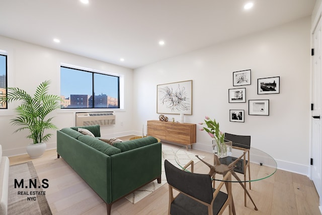 living room featuring a wall mounted air conditioner and light wood-type flooring