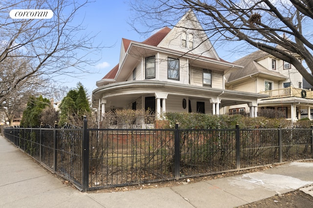 view of home's exterior with covered porch and a fenced front yard