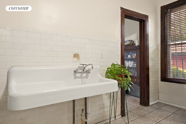 bathroom with tile walls, sink, and tile patterned floors