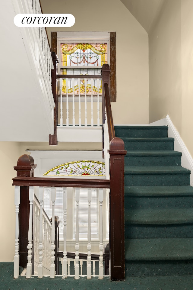 stairway featuring lofted ceiling and carpet