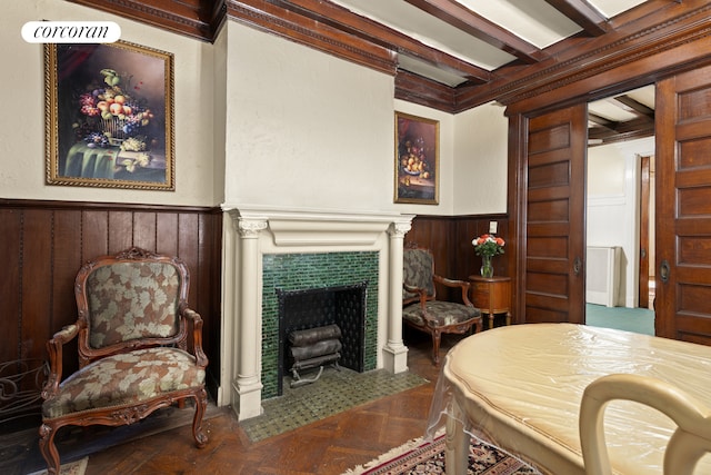 interior space featuring a wainscoted wall, wooden walls, a fireplace, and beamed ceiling