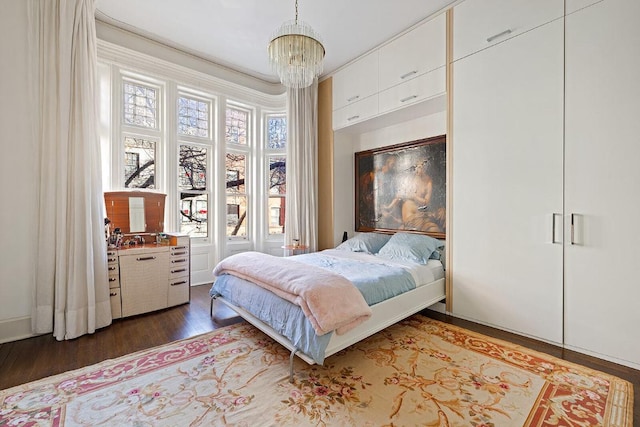 bedroom with dark hardwood / wood-style flooring and a chandelier