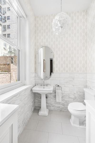 bathroom with tile walls, tile patterned flooring, and toilet