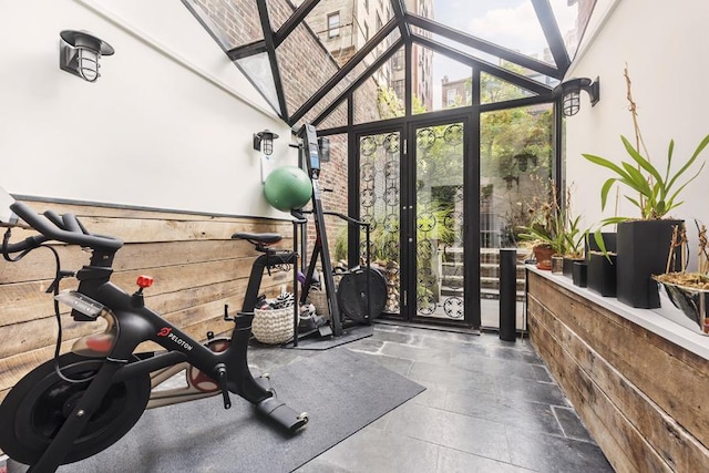 workout area featuring wooden walls and high vaulted ceiling