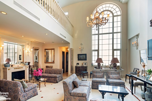 living room featuring a towering ceiling, ornamental molding, and a chandelier