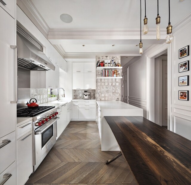 kitchen with sink, crown molding, high end range, dark parquet floors, and white cabinets