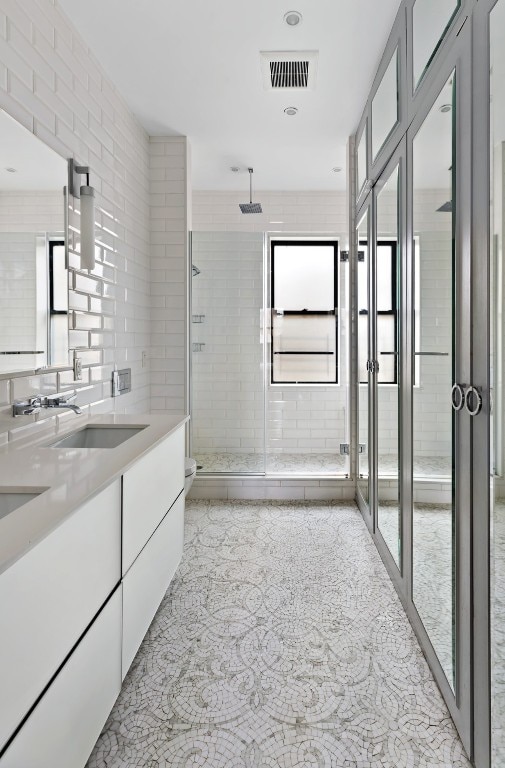 bathroom with a shower with door, vanity, and toilet