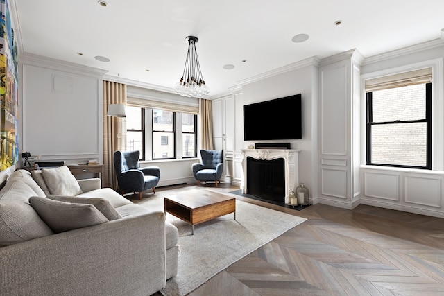 living area with ornamental molding, a chandelier, a fireplace, and a decorative wall