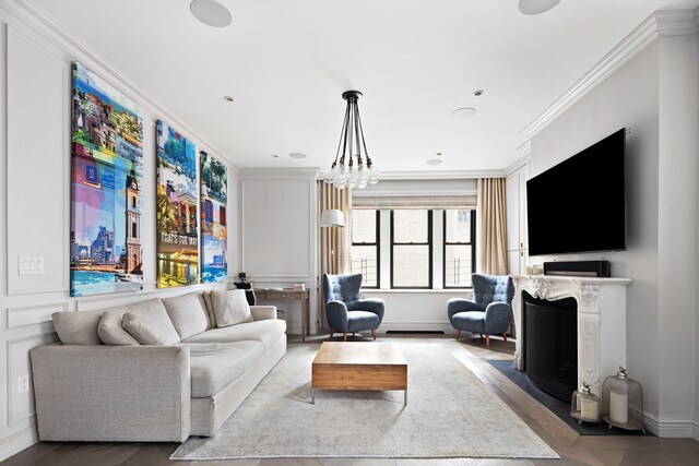 living room featuring crown molding, a fireplace, a chandelier, and light parquet floors