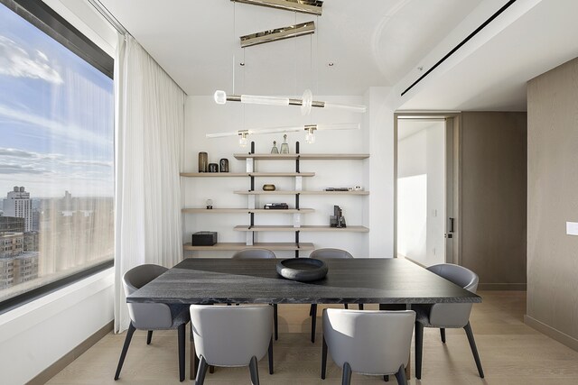 kitchen with tasteful backsplash, sink, a breakfast bar area, a center island with sink, and light hardwood / wood-style flooring