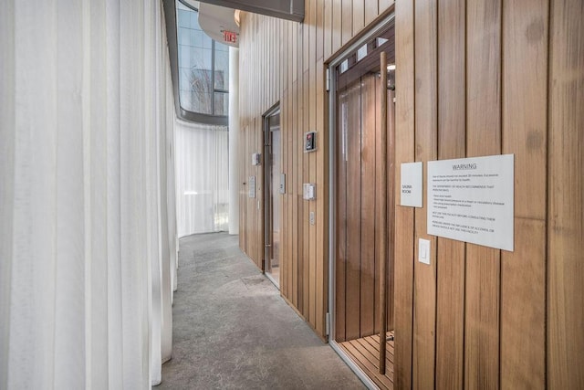 corridor with carpet floors and wood walls