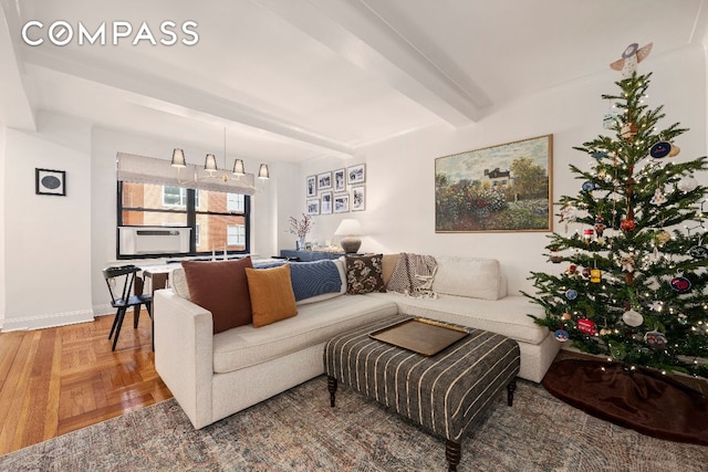 living area with cooling unit, beam ceiling, and baseboards