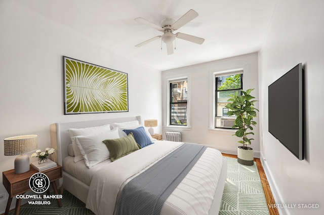 bedroom with radiator, a ceiling fan, wood finished floors, cooling unit, and baseboards