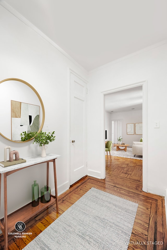 hallway featuring baseboards, ornamental molding, and wood finished floors