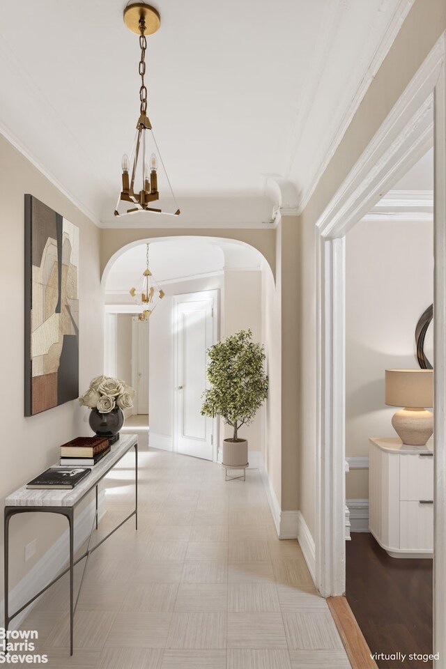 hall with crown molding and a chandelier