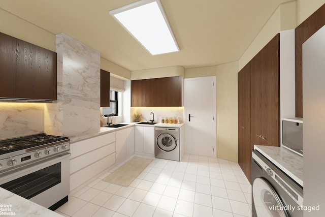 kitchen featuring a sink, stainless steel range with gas cooktop, and washer / dryer