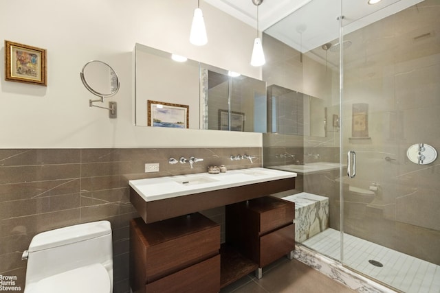 bathroom with tile patterned floors, toilet, a shower with shower door, tile walls, and vanity