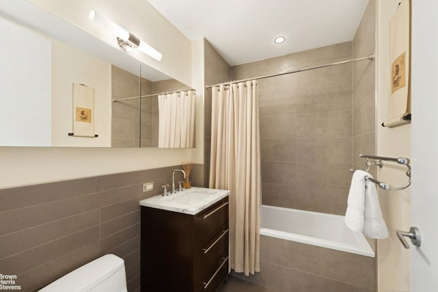 full bathroom with shower / bathtub combination with curtain, vanity, tile walls, and toilet