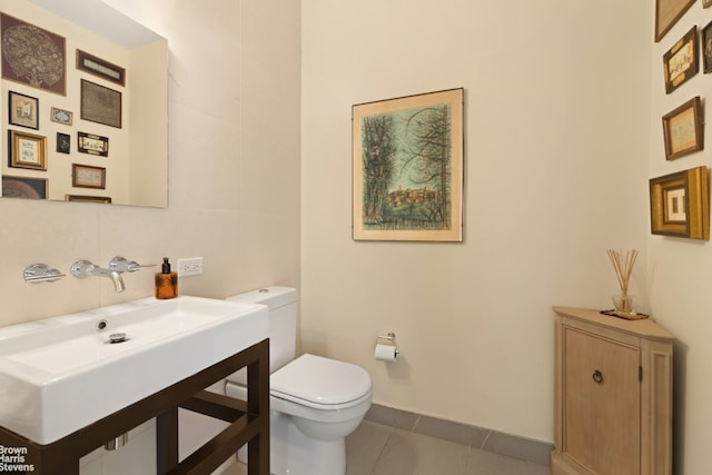 bathroom featuring sink, tile patterned floors, and toilet