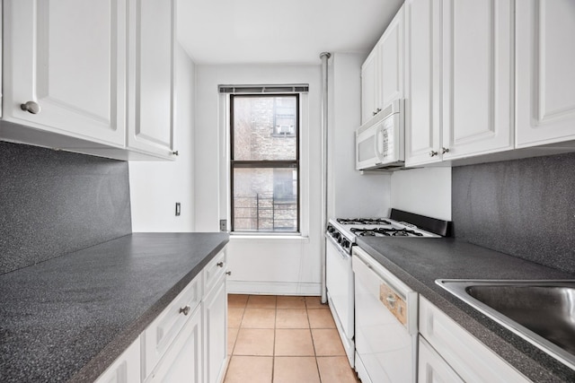 kitchen with light tile patterned flooring, sink, white cabinets, and white appliances