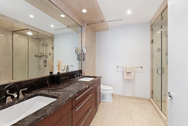 bathroom with vanity, a shower with shower door, and toilet