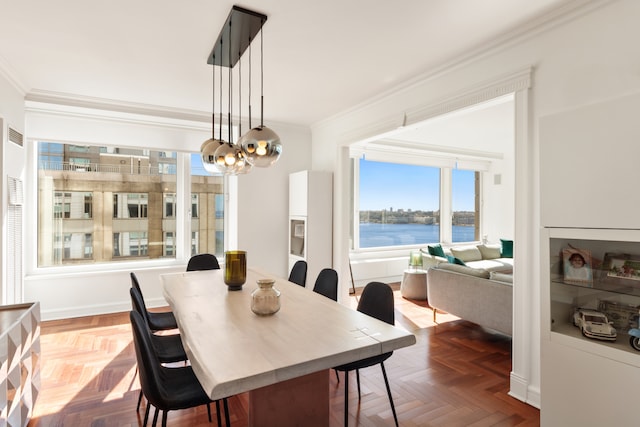 dining space with ornamental molding, a water view, and an inviting chandelier