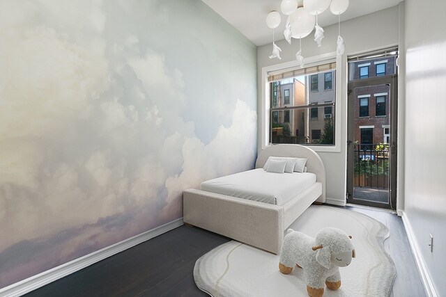 bedroom featuring baseboard heating, a skylight, and hardwood / wood-style floors