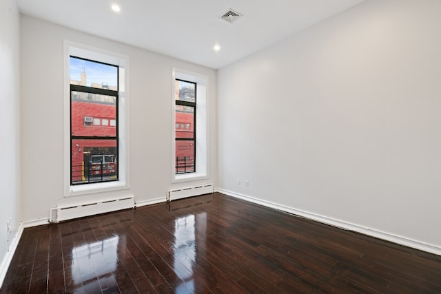 spare room featuring a baseboard radiator and hardwood / wood-style floors