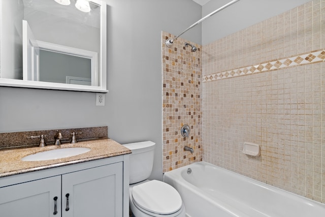 full bathroom with tiled shower / bath, vanity, and toilet