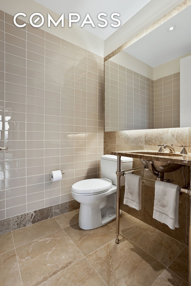 half bath with toilet and tile walls