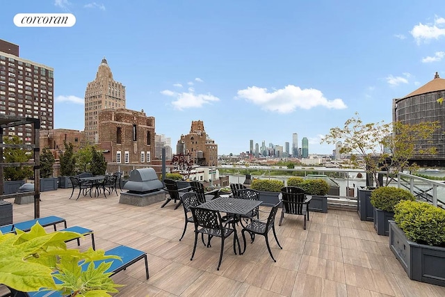 view of patio / terrace featuring area for grilling, outdoor dining area, and a city view