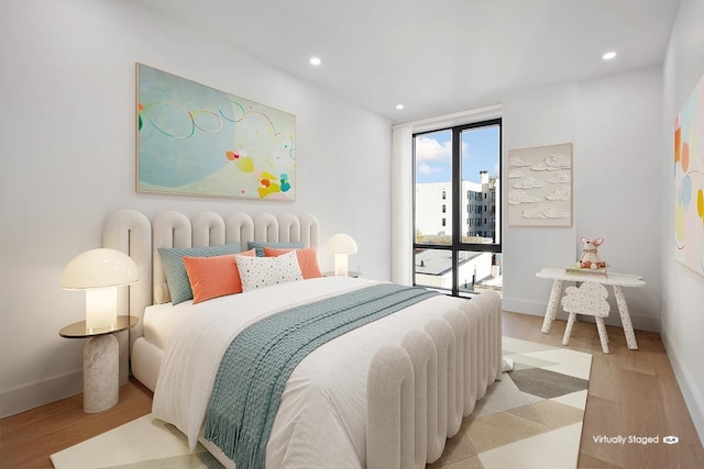 bedroom featuring light wood-type flooring and expansive windows