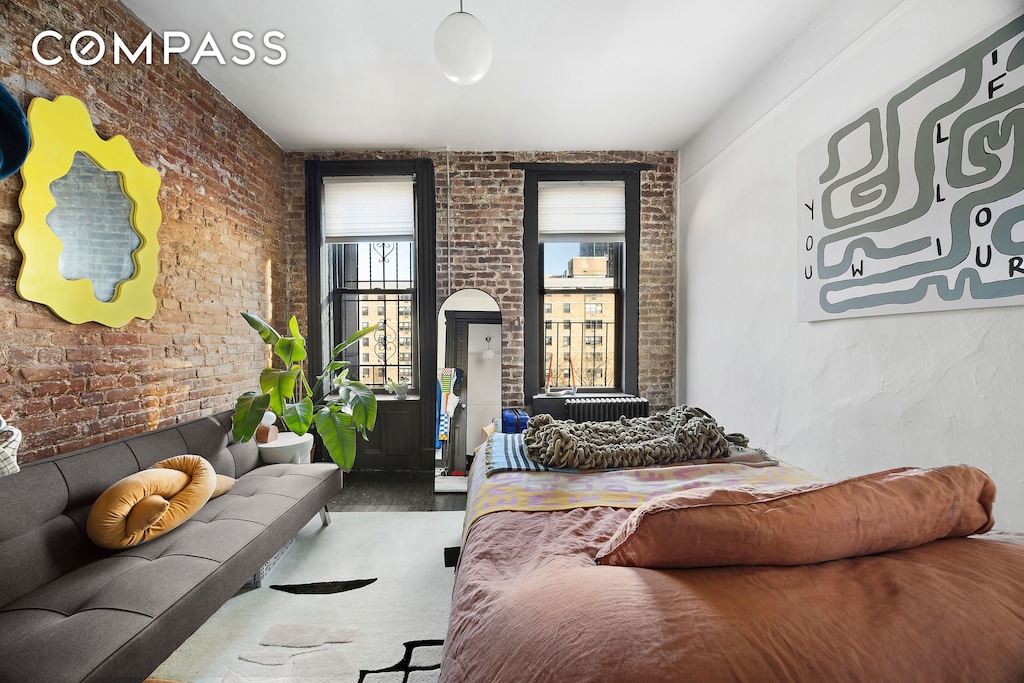 bedroom featuring brick wall