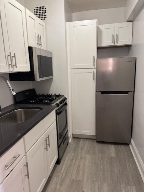3400 Snyder Ave Unit 5E, New York City, NY 11203 - kitchen with white cabinets, stainless steel appliances, dark countertops, and light wood-style floors