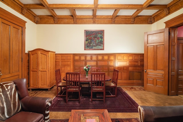 dining space featuring coffered ceiling, beam ceiling, a wainscoted wall, and a decorative wall