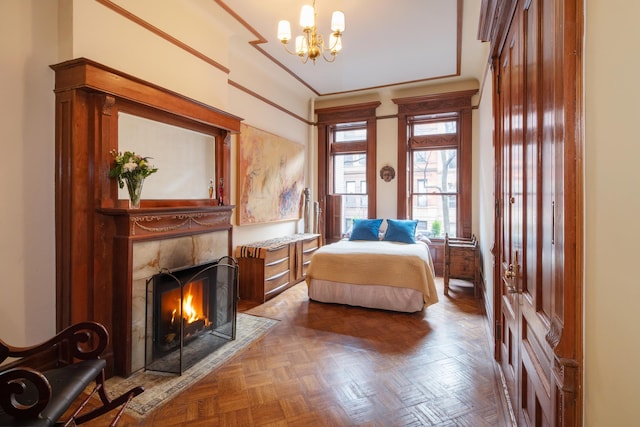 bedroom featuring a fireplace and a chandelier